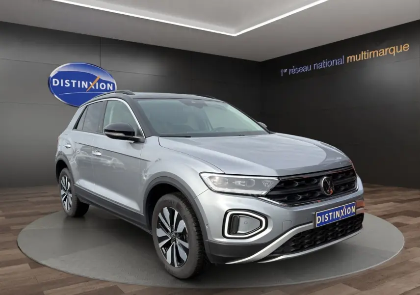 Volkswagen T-Roc gris clair en 3/4 avant droit, avec calandre noire et jantes alliage distinctives.