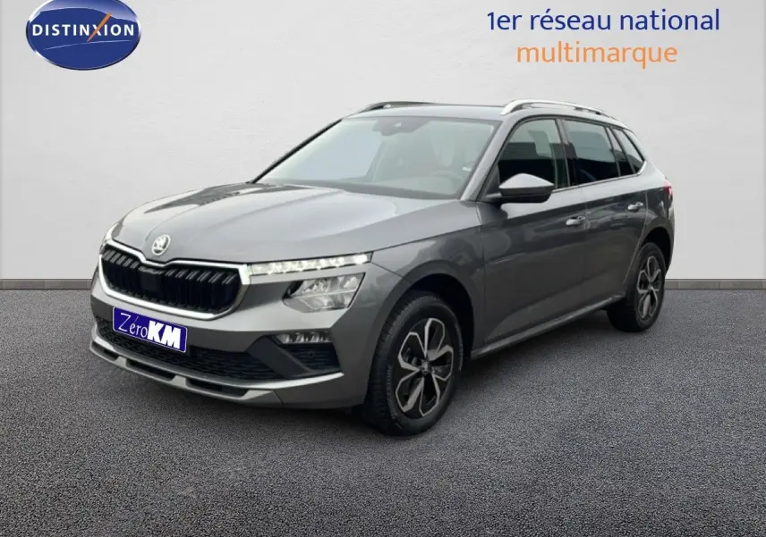 Vue 3/4 avant d'un Skoda Kamiq gris graphite 2025 avec jantes bi-ton et calandre noire distinctive.
