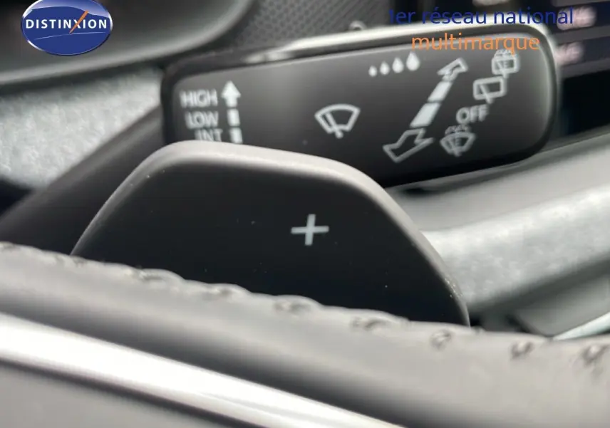 Gros plan sur la palette de changement de vitesse "+" derrière le volant d'un Skoda Kamiq gris graphite, version 2025.