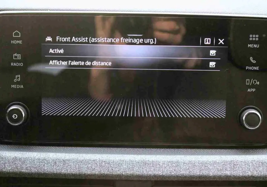 Écran tactile central affichant l'activation de l'assistance freinage d'urgence dans un Skoda Kamiq 2025.