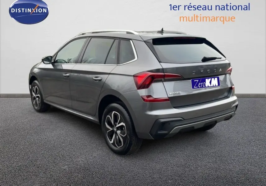 Vue 3/4 arrière droite d'un Skoda Kamiq gris graphite avec jantes alliage et toit ouvrant, sur fond neutre.