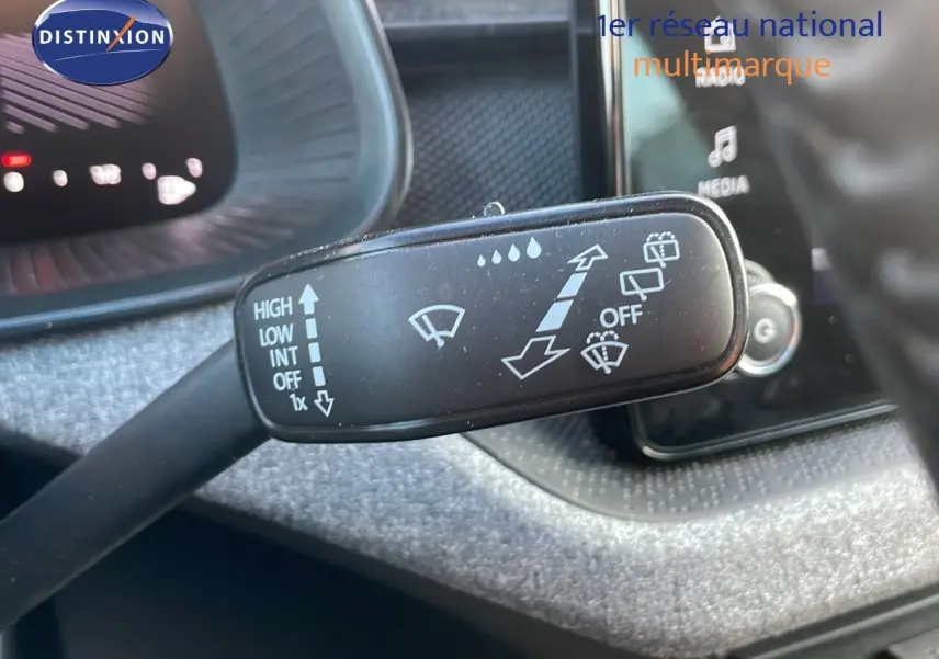 Gros plan sur la commande d’essuie-glace du Skoda Kamiq 2024, intérieur avec tableau de bord et écran tactile en arrière-plan.