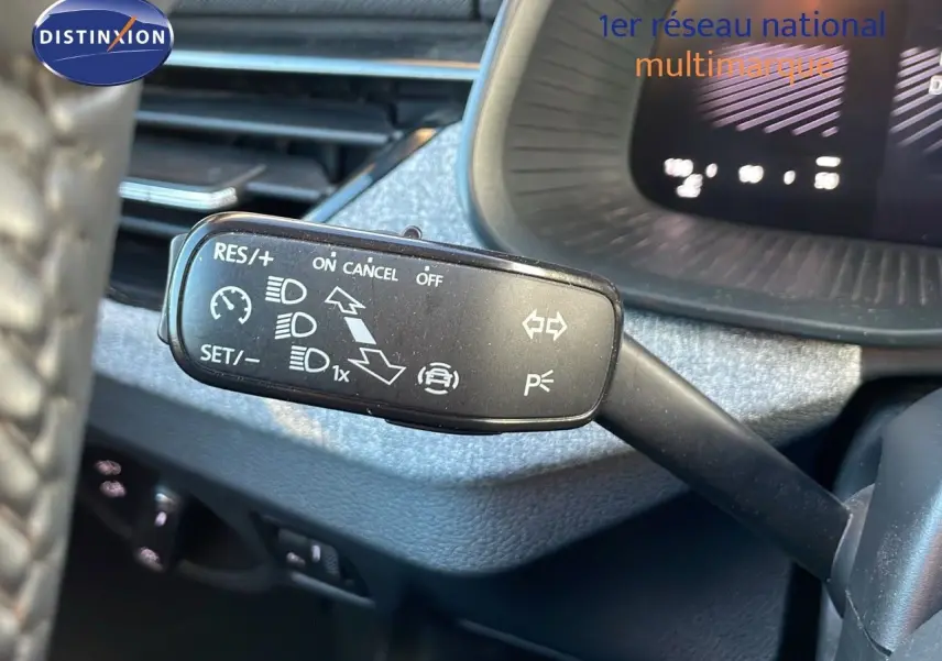 Gros plan sur le commodo gauche du tableau de bord d’un Skoda Kamiq 2024 gris graphite, montrant les commandes de régulateur et feux.