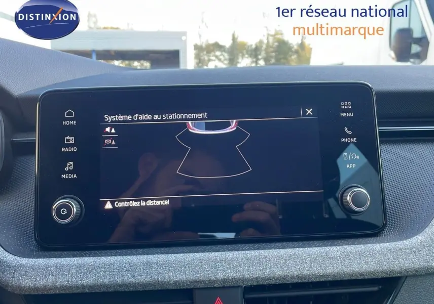 Écran tactile central du Skoda Kamiq 2024 affichant le système d'aide au stationnement dans un intérieur gris.