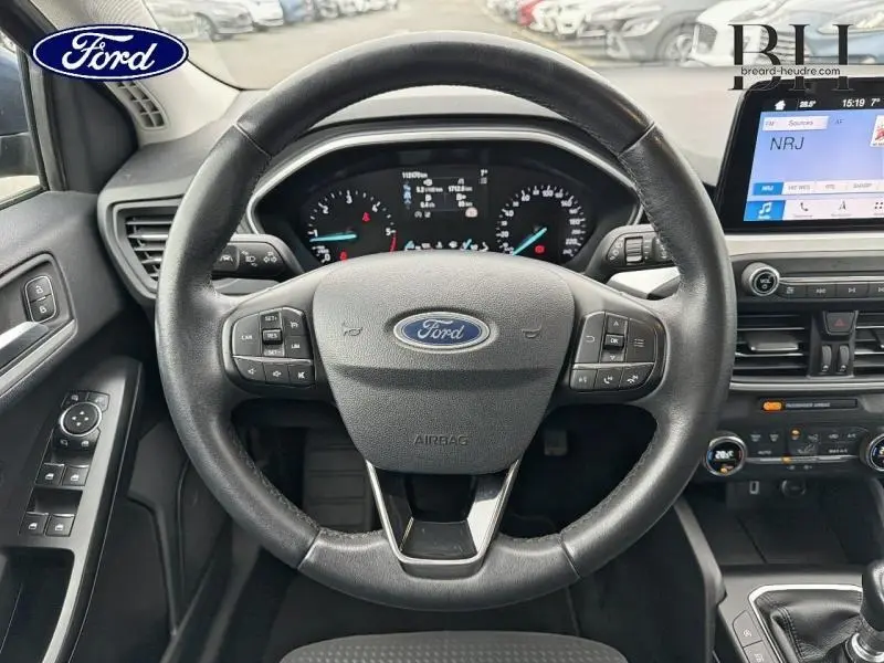 Vue intérieure centrée sur le volant cuir multifonction d'une Ford Focus SW 2019 avec tableau de bord et écran tactile.