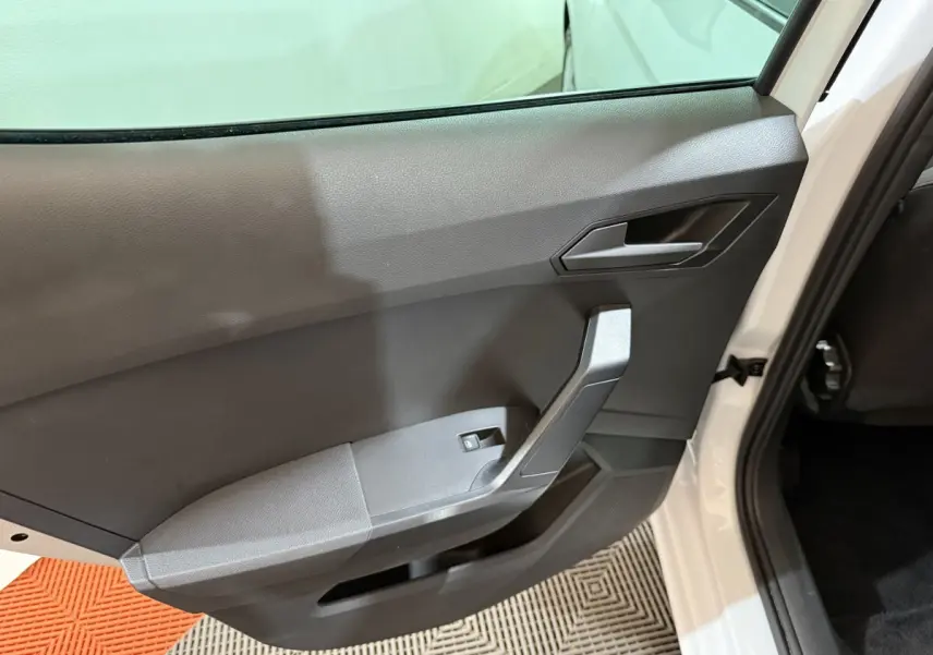 Vue intérieure côté gauche de la porte arrière blanche d'une SEAT IBIZA 2024 avec poignée et bouton de lève-vitre noir.