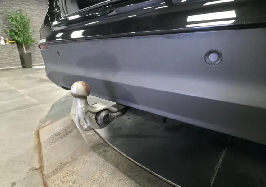 Vue rapprochée du crochet d'attelage escamotable à l'arrière d'un Volkswagen Tiguan noir 2025.