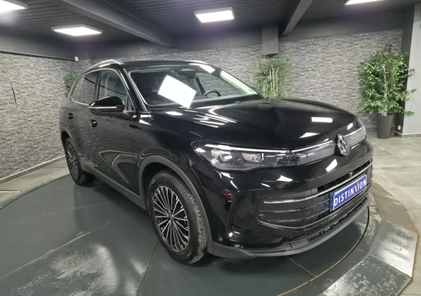 Volkswagen Tiguan noir en 3/4 avant droit, avec jantes alliage 18 pouces et calandre moderne brillante.