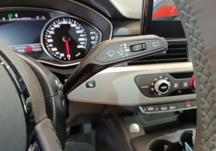 Gros plan sur la manette d’essuie-glace côté gauche du tableau de bord beige et noir d’une Audi A4 35 TFSI 2024.