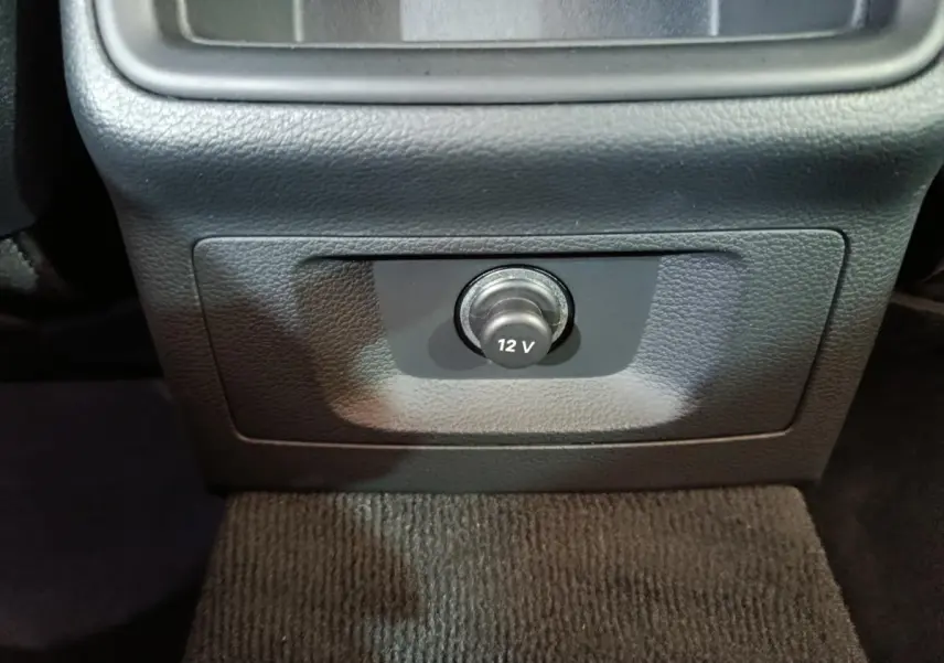 Prise 12V en gros plan sur la console centrale noire de l’Audi A4 35 TFSI Business Line 2024.