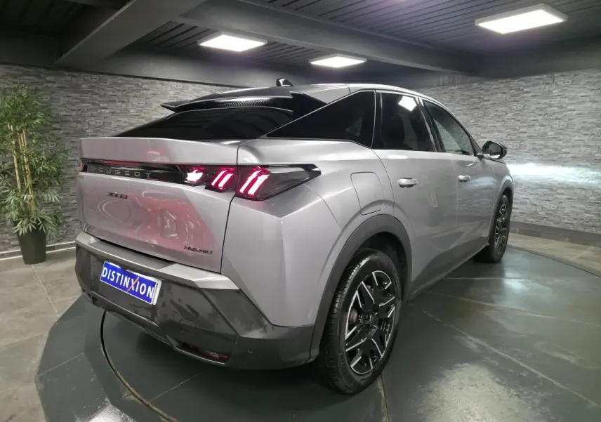 Vue 3/4 arrière droite du Peugeot 3008 hybride gris métallisé avec feux arrière LED à 3 griffes et jantes alliage noires.