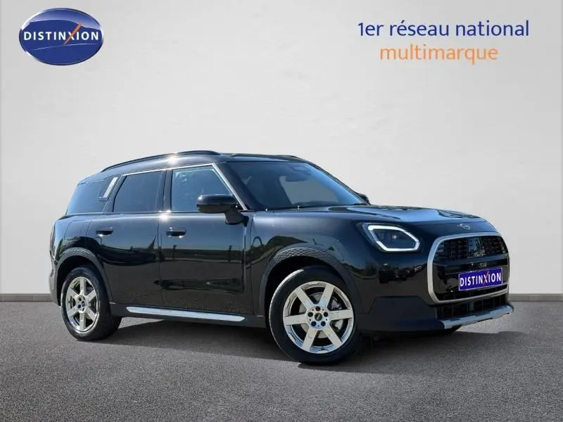 Mini Countryman D 163ch Favoured 2024 en Midnight Black II, vue 3/4 avant droit avec jantes argentées distinctives.