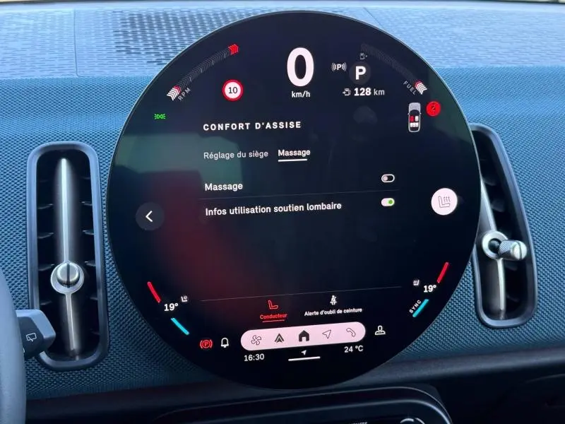 Vue rapprochée du tableau de bord numérique circulaire du MINI Countryman 2024 en Midnight Black II, affichant le menu confort d'assise.