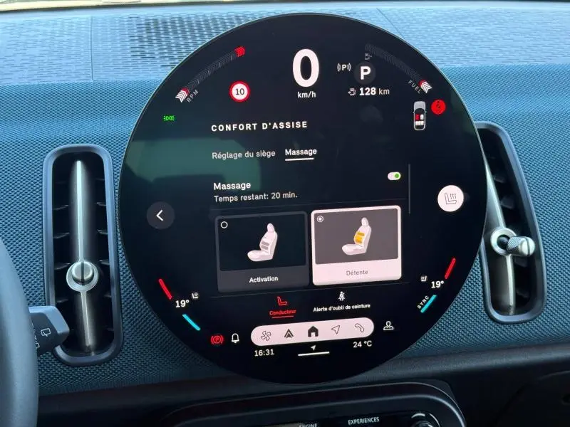 Tableau de bord circulaire de MINI Countryman 2024, affichage digital du confort d'assise et massage, intérieur noir.