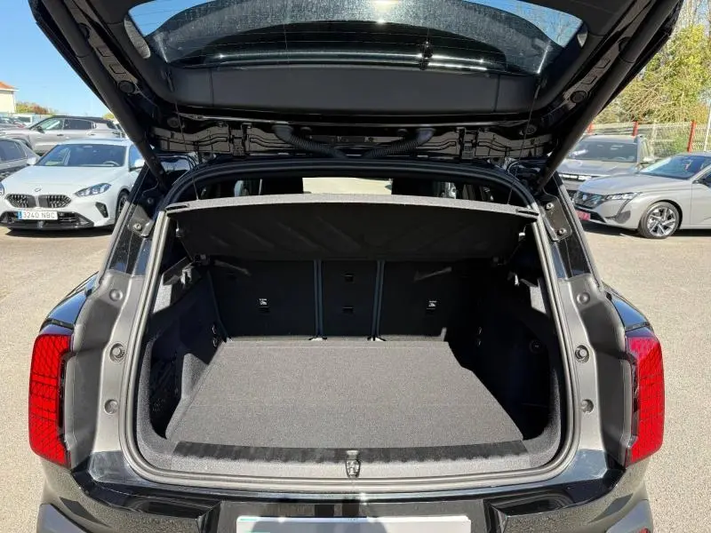 Vue arrière ouverte du coffre du MINI COUNTRYMAN 2024 Midnight Black II, soulignant l'espace de chargement vide et la finition intérieure noire.