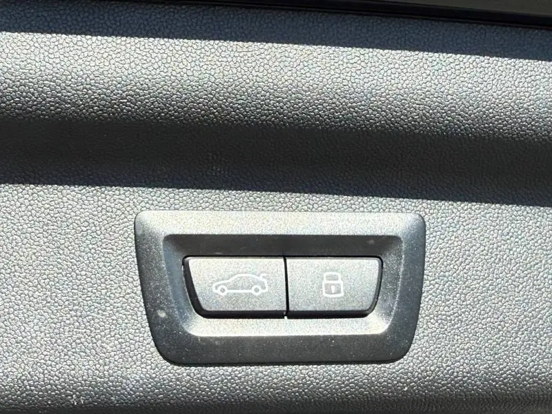 Gros plan sur les boutons d'ouverture du coffre et de verrouillage intérieur du MINI COUNTRYMAN 2024 en Midnight Black II.