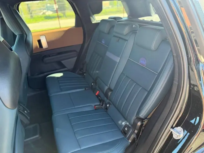 Vue intérieure côté droit des sièges arrière en cuir noir du MINI Countryman 2024 avec logo MINI brodé sur les appuie-têtes.