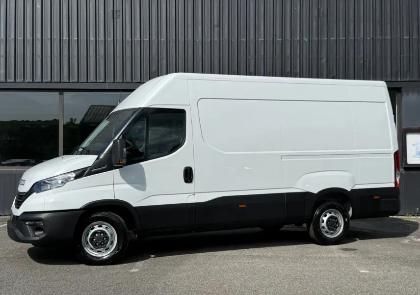Fourgon Iveco Daily blanc vu de profil côté gauche, soulignant sa silhouette haute et ses détails noirs bas de caisse.
