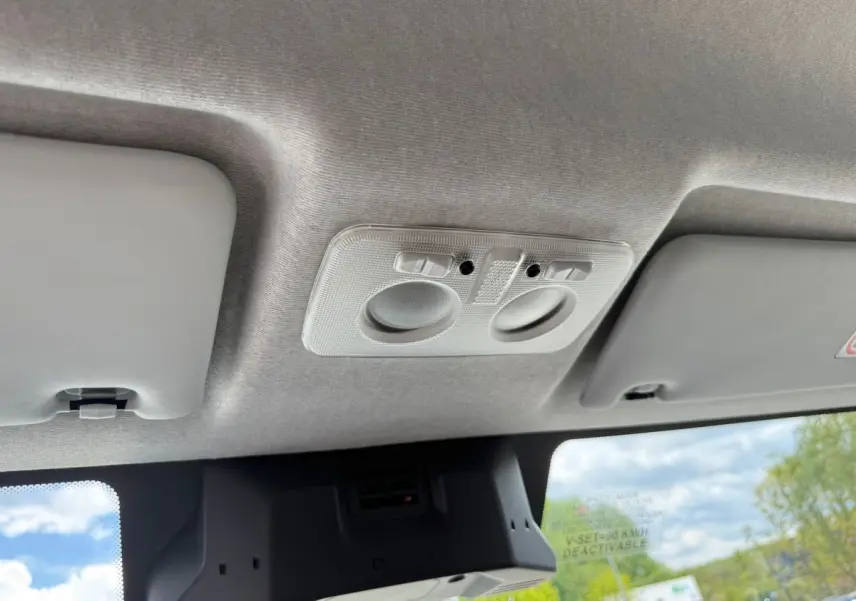 Vue intérieure du plafond avant du fourgon Iveco Daily blanc 2026, montrant les plafonniers et pare-soleils.