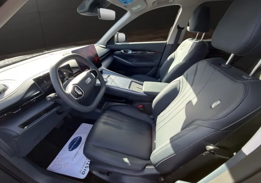 Intérieur avant droit du Geely E5 gris foncé 2026, sièges cuir noirs et tableau de bord avec écran tactile central.