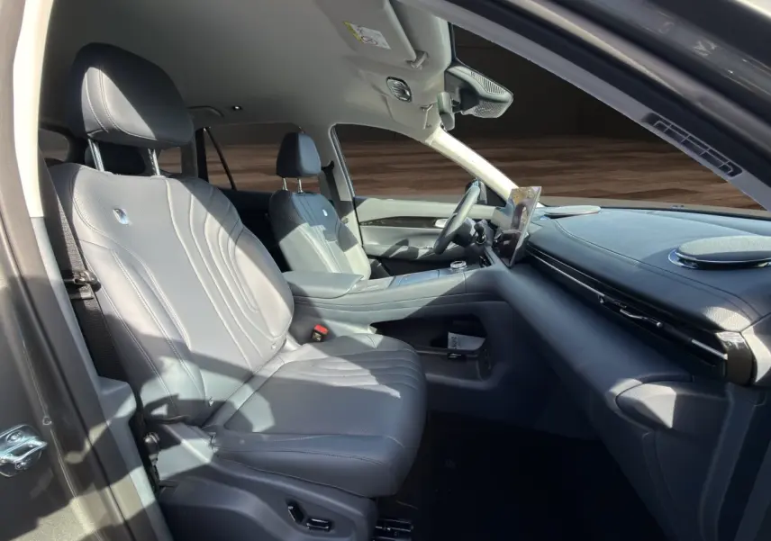 Vue intérieure côté gauche du Geely E5 2026 gris foncé, avec sièges en cuir et tableau de bord moderne.
