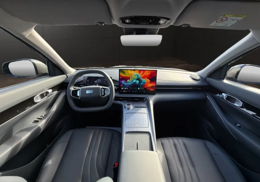 Vue intérieure avant du Geely E5 gris foncé 2026, avec tableau de bord moderne et écran tactile central coloré.