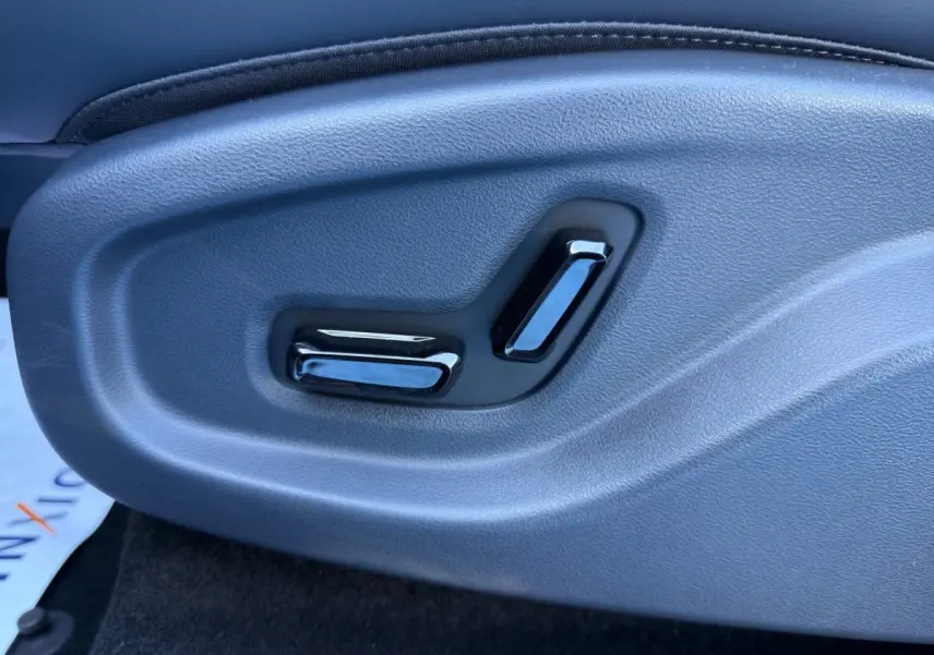 Détail des commandes de réglage électrique du siège côté conducteur dans un GEELY E5 gris foncé 2026.