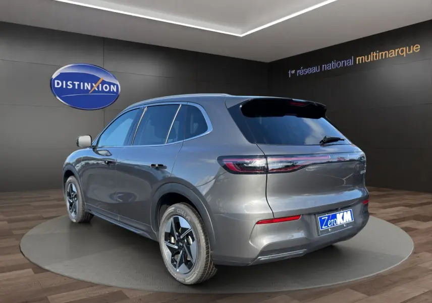 Vue 3/4 arrière droite du SUV électrique GEELY E5 gris foncé, avec feux arrière connectés et jantes modernes.