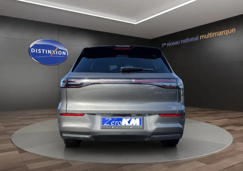 Vue arrière d’un SUV électrique Geely E5 gris foncé, avec feux arrière étirés et plaque d’immatriculation Zero KM.
