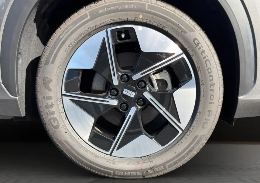 Gros plan sur la roue avant droite du Geely E5 gris foncé 2026 avec jante noire et argentée au design moderne.