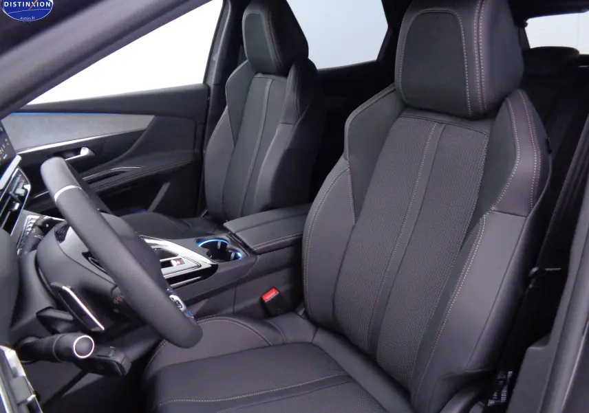 Vue intérieure côté conducteur du Peugeot 3008 2023, sièges en cuir noir avec surpiqûres contrastées et console centrale moderne.