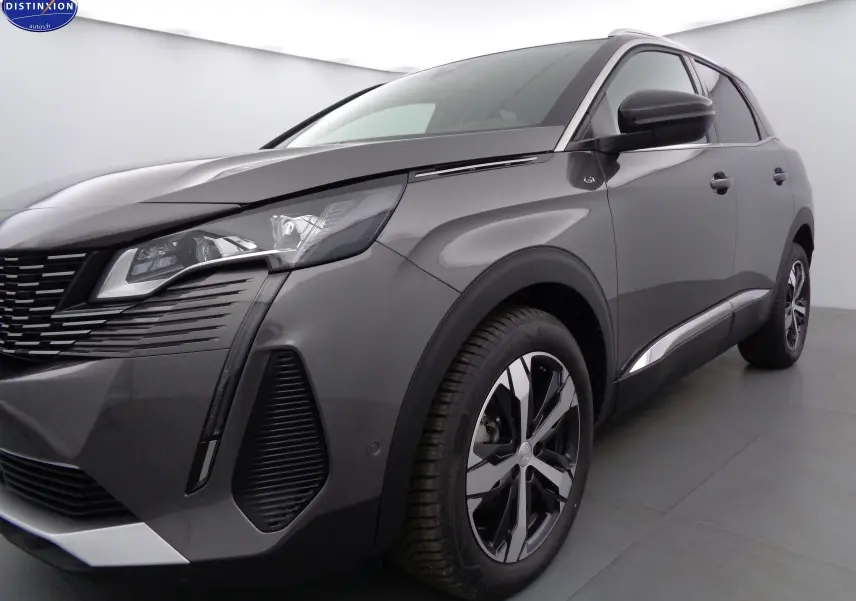 Vue 3/4 avant droit d'un Peugeot 3008 gris platinium métal avec jantes alliage bicolores et calandre distinctive.