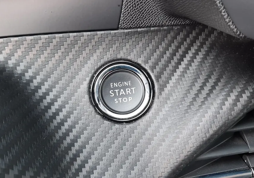 Bouton démarrage moteur circulaire sur tableau de bord effet carbone intérieur Peugeot 2008 gris 2021 finition Allure.
