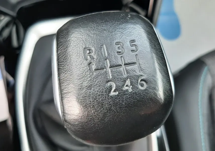 Gros plan sur le levier de vitesses manuel noir du Peugeot 2008 gris, montrant les six rapports et la marche arrière.