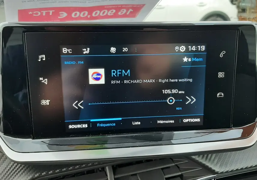 Écran tactile central affichant la radio RFM dans l'habitacle noir d'un Peugeot 2008 gris 2021.