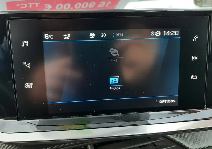 Écran tactile central du tableau de bord du Peugeot 2008 gris, affichant les options multimédia et la température extérieure.