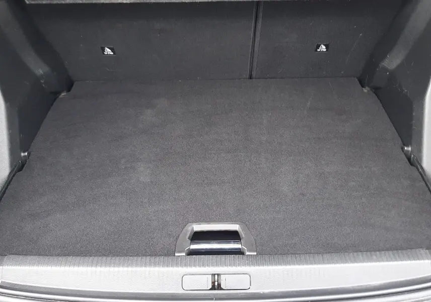 Coffre ouvert vu de l'arrière d'un Peugeot 2008 gris, montrant un espace de chargement propre et bien fini.