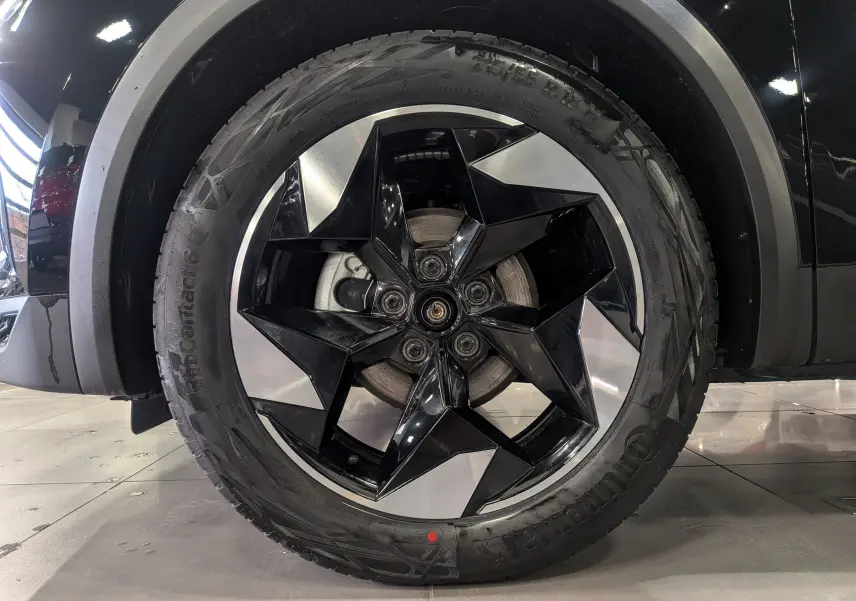 Gros plan sur la roue avant droite du Renault Captur noir 2025, mettant en valeur la jante bi-ton originale.