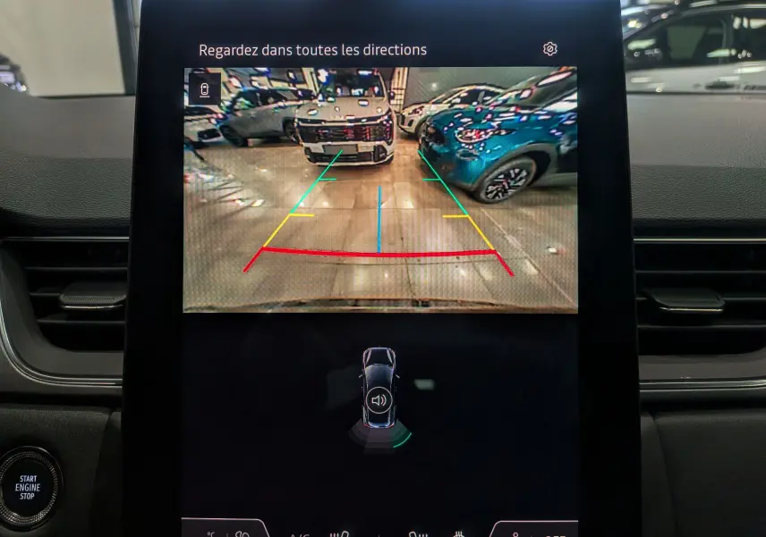 Écran central du Renault Captur 2025 affichant la caméra de recul avec guidage coloré en intérieur de garage.