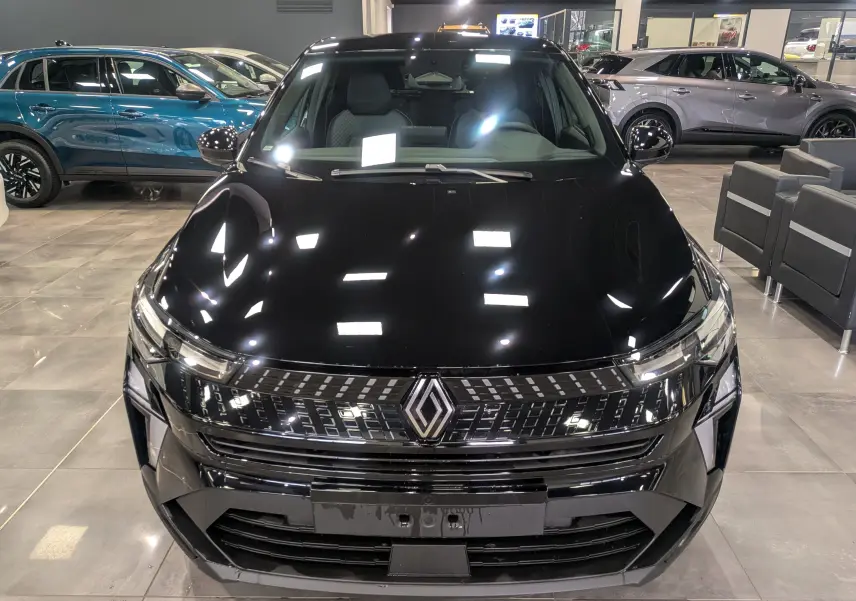 Vue frontale d'un Renault Captur noir 2025 avec calandre moderne et éclairage LED en showroom.