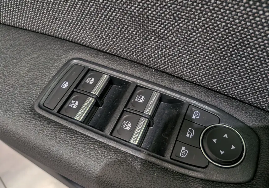 Panneau de commandes des vitres électriques et réglage des rétroviseurs sur porte intérieure tissu noir du Renault Captur 2025.