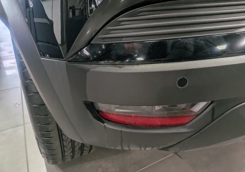 Gros plan sur le feu arrière droit noir du Renault Captur Mild Hybrid 160 CH EDC TECHNO 2025 avec capteur de recul.