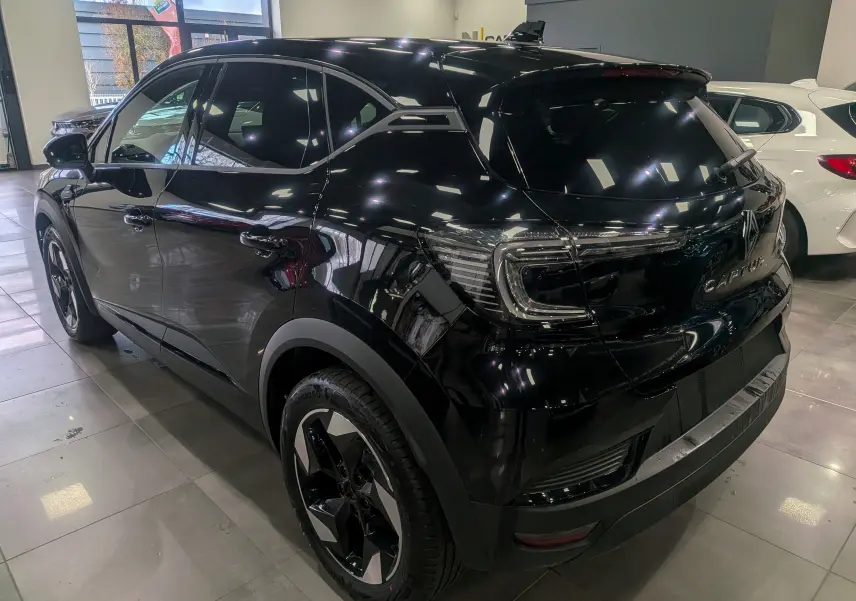 Renault Captur 2025 noir en vue 3/4 arrière droit, avec feux arrière LED et jantes bi-ton distinctives.