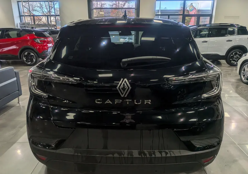 Vue arrière d'un Renault Captur noir 2025 en showroom, mettant en valeur son logo et ses feux LED fins.