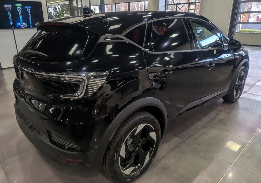 Renault Captur noir en 3/4 arrière droit, mettant en valeur ses feux LED et jantes biton modernes.