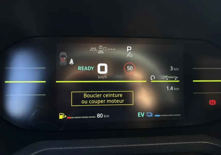 Tableau de bord digital du Dacia Duster blanc glacier 2026 affichant la vitesse et alertes de sécurité.