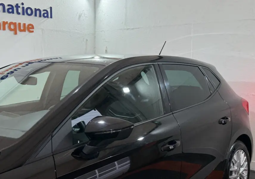Vue latérale droite d'une SEAT Ibiza 1.0 TSI 110 FR noire, avec rétroviseurs ton caisse et jantes alliage visibles.