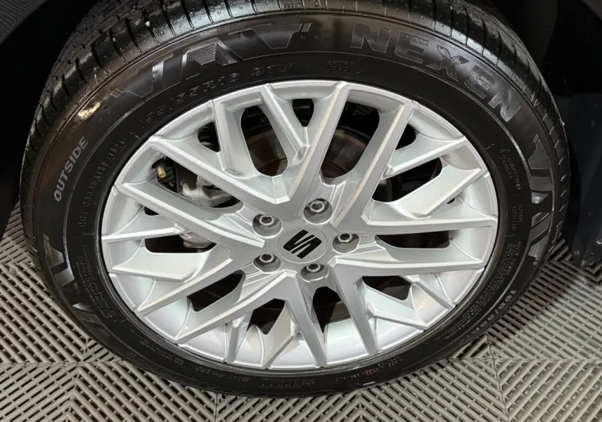 Vue de profil côté droit d'une SEAT Ibiza 1.0 TSI 110 FR noire avec jantes alliage et rétroviseurs ton caisse.