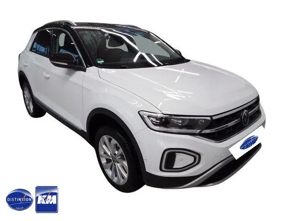 Volkswagen T-Roc blanc toit noir en vue 3/4 avant droit, avec jantes alliage et calandre distinctive.