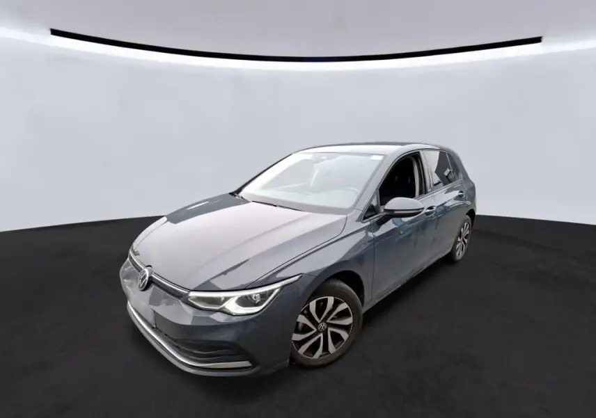 Volkswagen Golf 1.5 eTSI gris vue 3/4 avant droit dans un studio avec phares LED allumés.